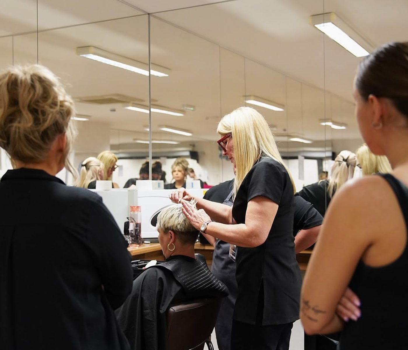 An Oracle tutor demonstrating cutting technique to learners in the training salon